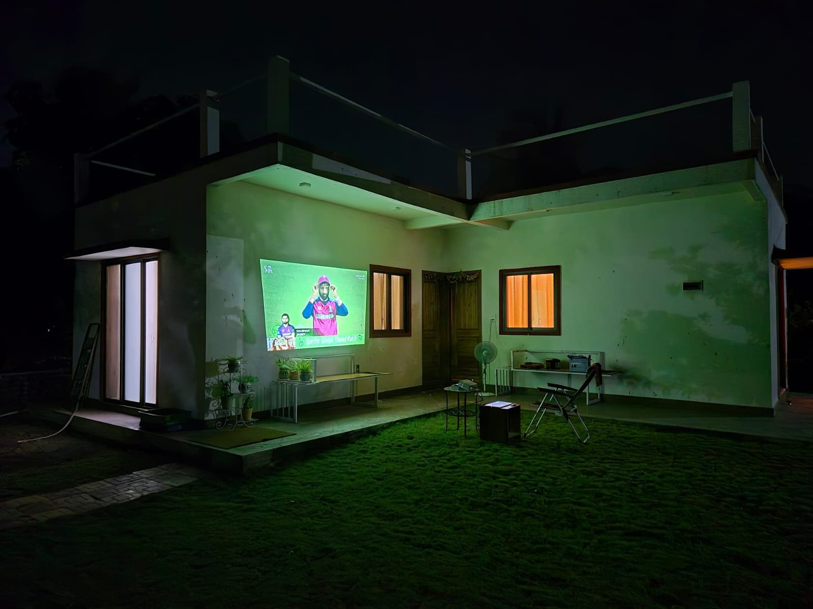 Outdoor projector screening on the lawn at night